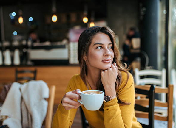 Junge Frau genießt im Café ihre Lebensqualität